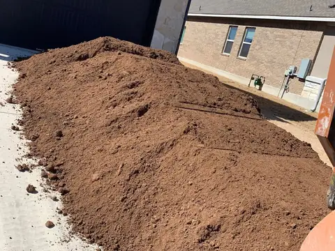 Landscape mix soil delivered beside a house