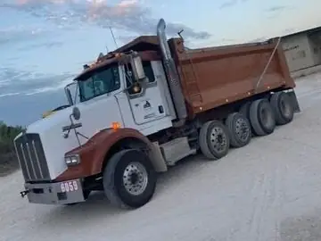 Barcenas Transportation dump truck parked at the yard at sunset