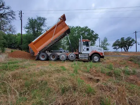 Barcenas Transportation dump truck unloading material on a job site
